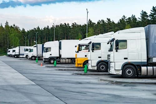 Weiße Sattelzüge auf einem beleuchteten Lkw-Hof von Secland